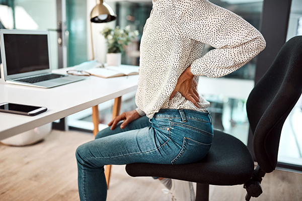 Woman sitting with aching lower back