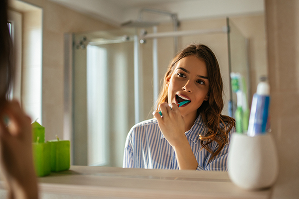 Young woman brushing teeth in the bathroom.