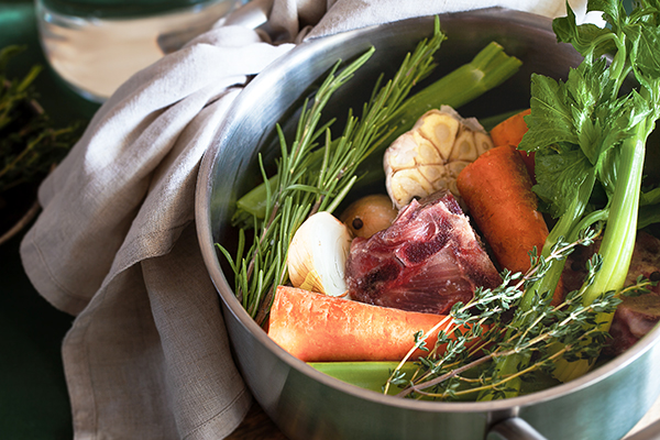 Ingredients for cooking bone broth in pot.