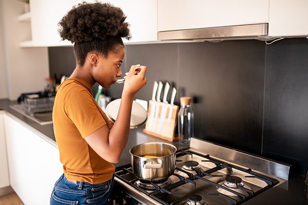 Woman cooking bone broth at home.