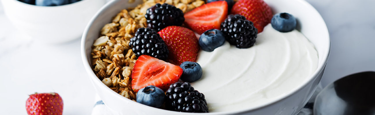 Greek yogurt, nuts, granola, berries in a bowl.