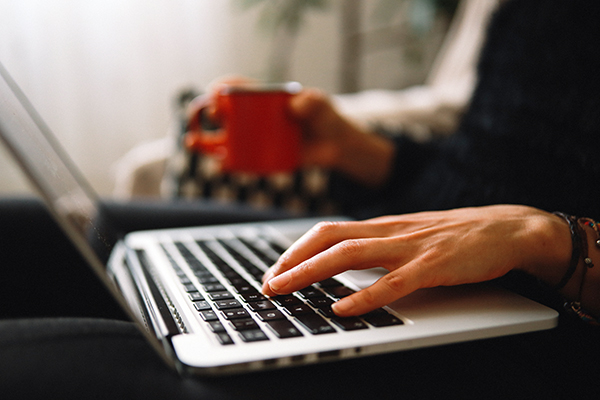 Close-up of woman's hands typing on laptop