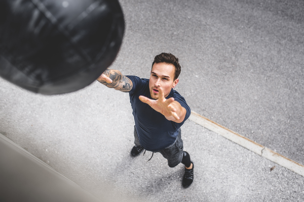 Man doing medicine ball squat and toss