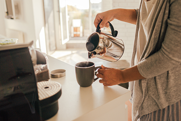 Woman making tea in her kitchen