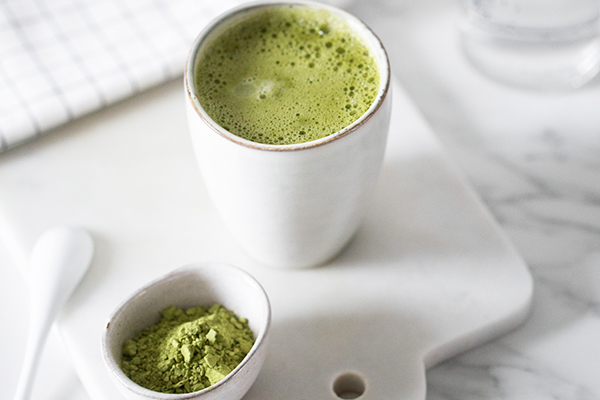 Cup of matcha tea and bowl of matcha powder