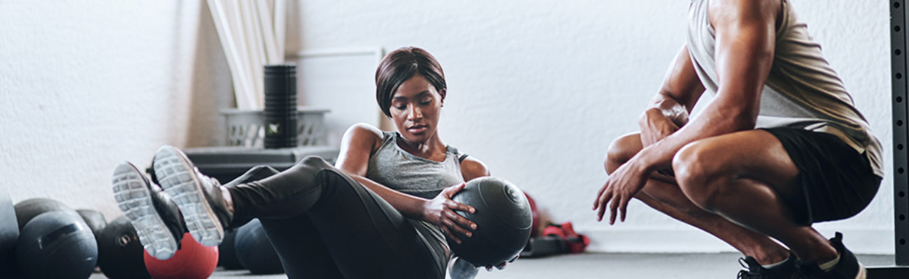 Woman exercising with medicine ball in gym.