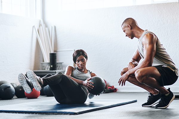 Woman exercising with medicine ball in gym.