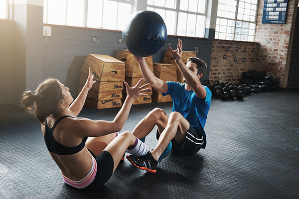 Man and woman throwing a medicine ball back and forth