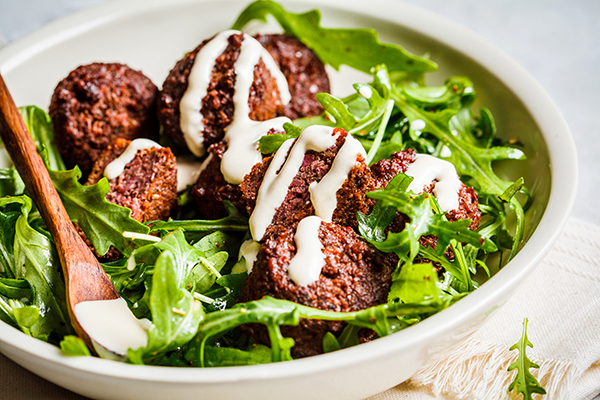 Falafel topped with tahini over greens