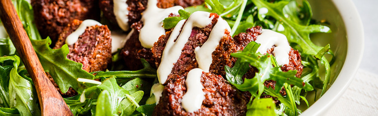 Falafel topped with tahini over greens