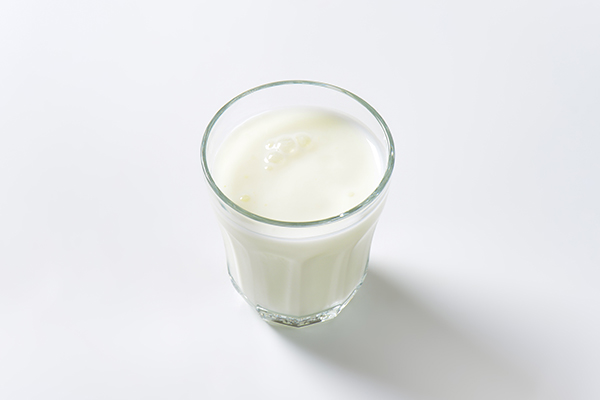 glass of almond milk on white background