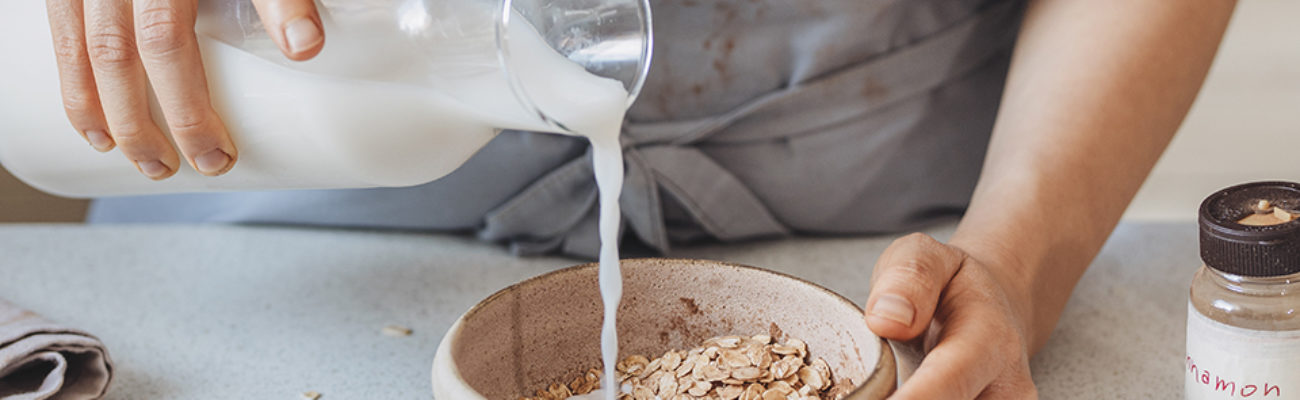 Woman preparing oatmeal with almond milk