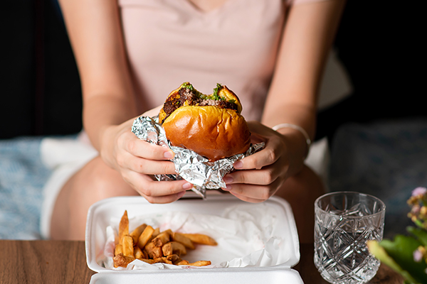 Woman eating burger and fries 