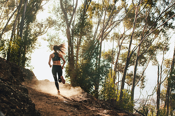 Woman trail running on a mountain path