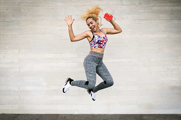 Young woman dancing with headphones and smartphone