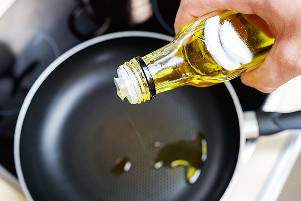 Olive oil pouring into pan