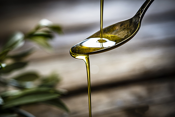 Pouring olive oil onto a spoon
