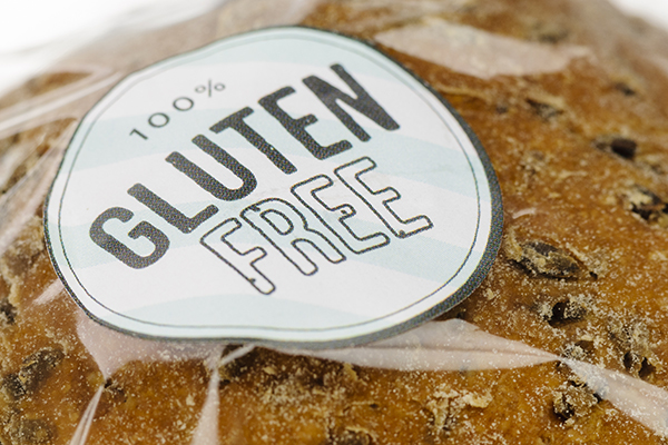 "100% Gluten Free" sticker on a loaf of brown bread.