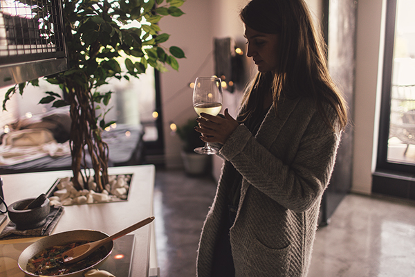 Woman drinking wine alone at home