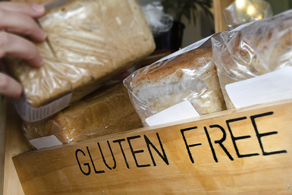 A woman hand picks up a Gluten Free loaf of bread.