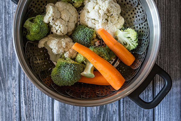 Freshly steamed vegetables on wooden table