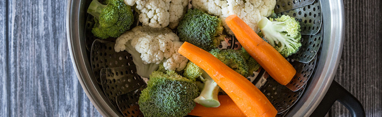 Freshly steamed vegetables on wooden table