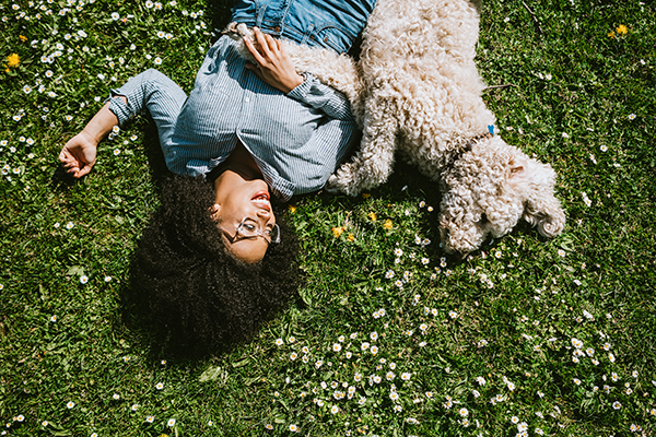 Woman lying in the grass with her dog