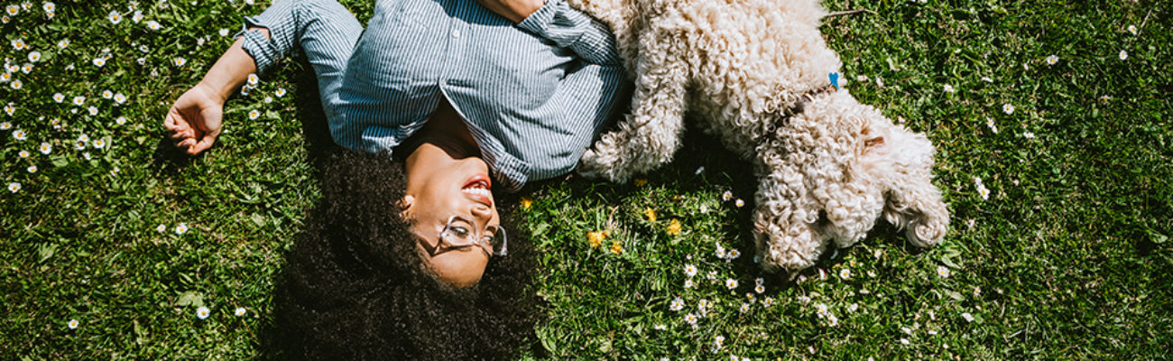 Woman lying in the grass with her dog