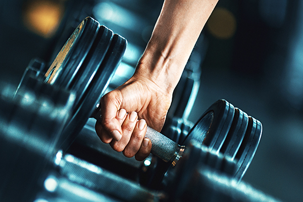 Woman lifting dumbbell off weight rack