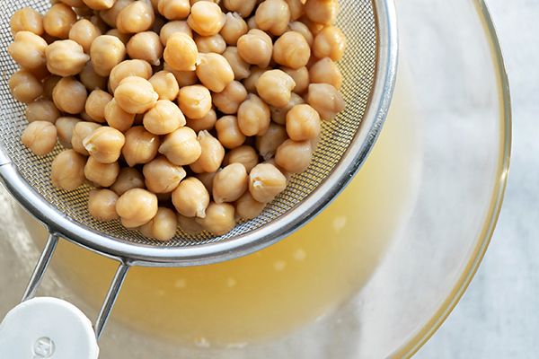 Cooked chickpeas draining aquafaba