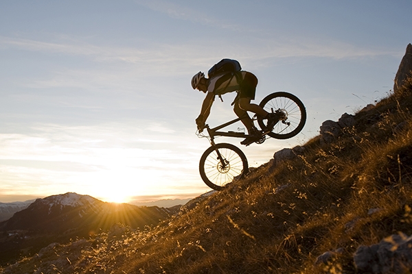 Mountain biker doing a jump on downhill trail.