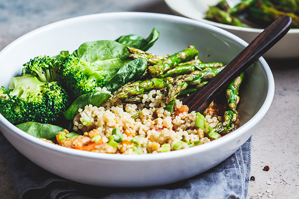 Bowl with quinoa, broccoli, asparagus in a bowl.