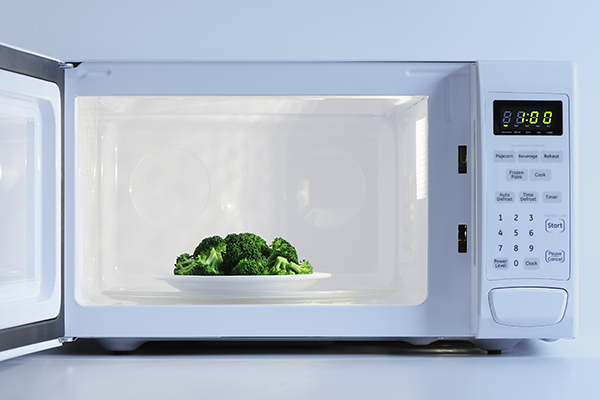 Plate of broccoli in a microwave.