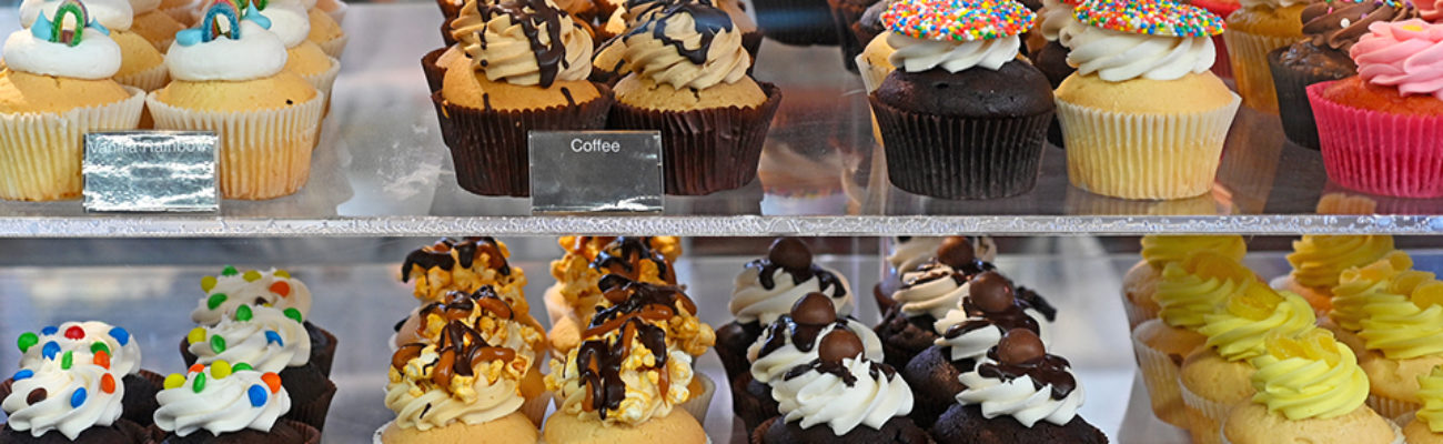 Bakery window with variety of cupcakes.