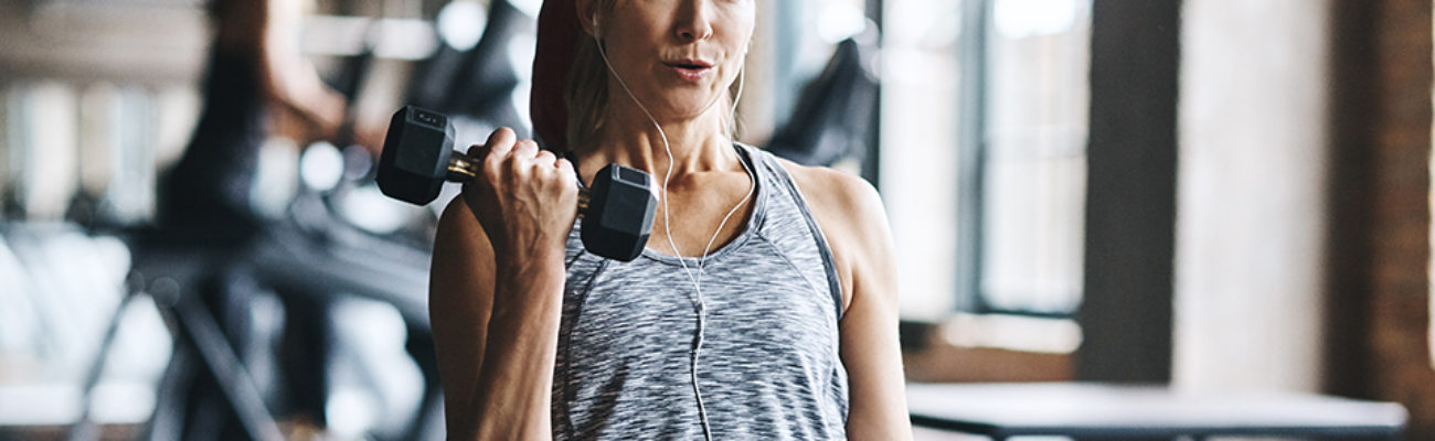 Mature woman lifting weights at the gym