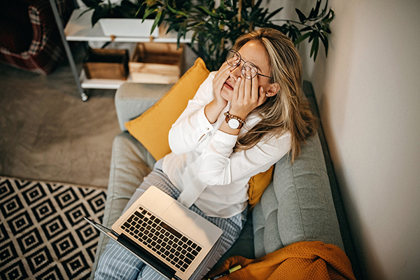 Woman using laptop on couch.