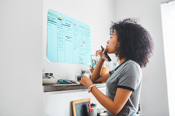 Woman looking at list of tasks to do on wall