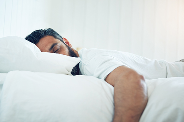 man lying in bed on his stomach