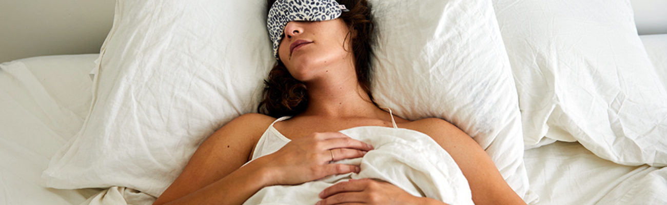 Woman lying in bed with eye mask