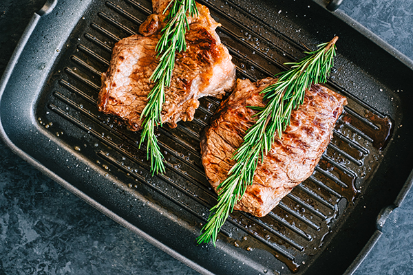 Bison meat steaks in frying pan