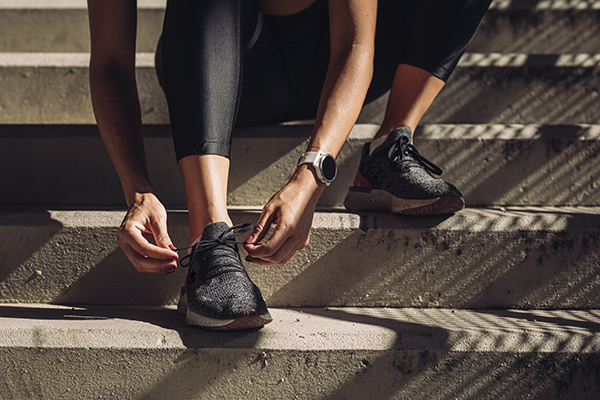 Female runner tying shoelaces on sneakers.