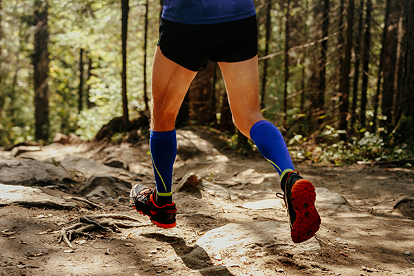 Man trail running wearing compression socks