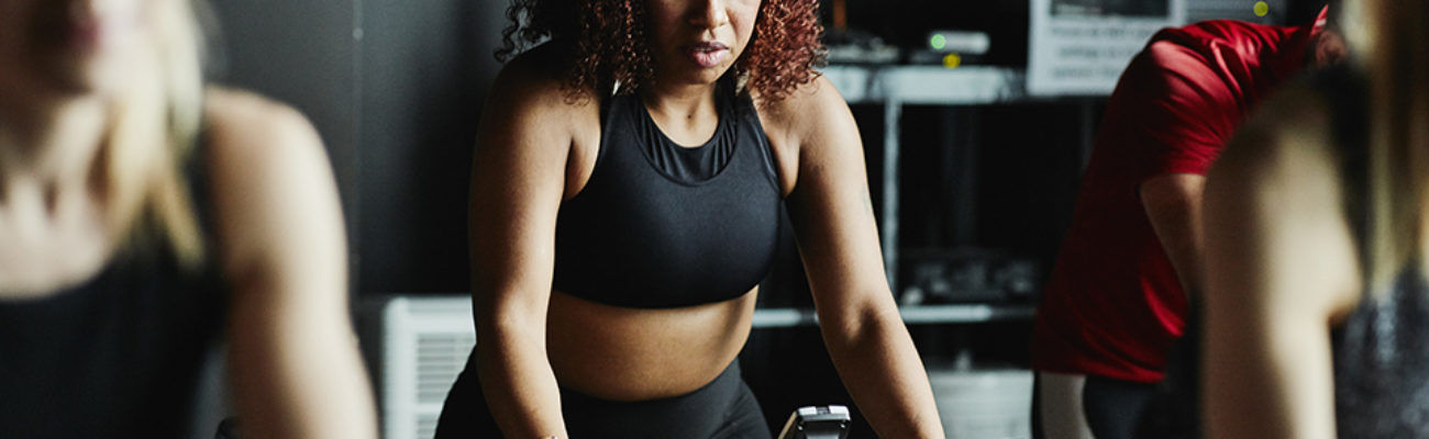 Woman riding stationary bike during class in cycling studio