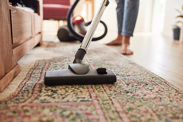 Woman vacuuming the living room at home
