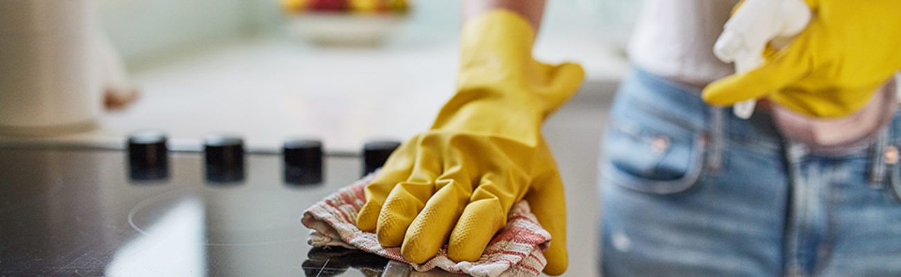 Cropped shot of a woman cleaning a kitchen counter at home