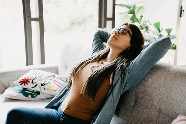 Woman relaxing at home, sitting on the sofa.