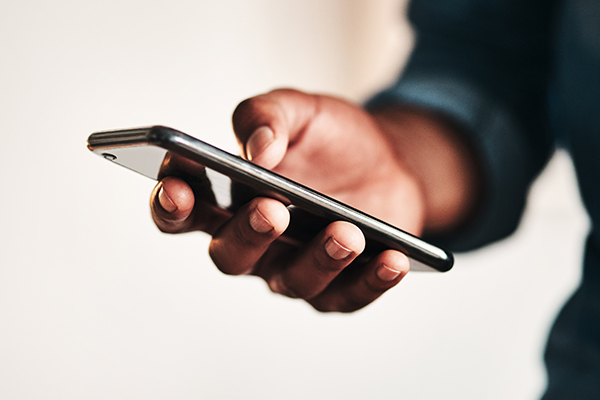 Cropped shot of man's hand holding smartphone