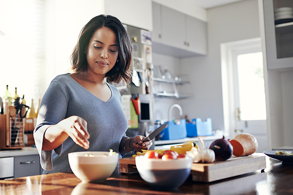 Woman chopping vegetables in kitchen