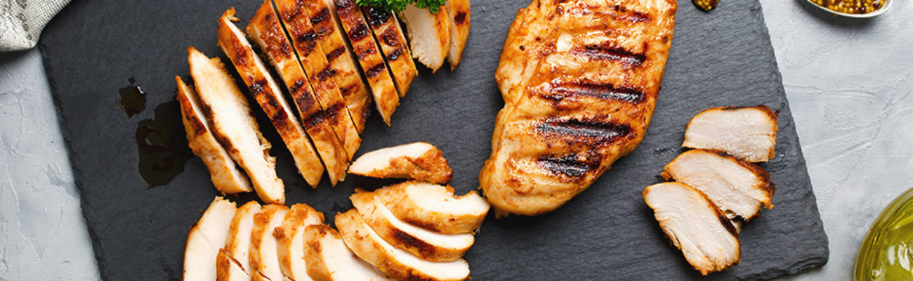 Grilled chicken fillets on plate.