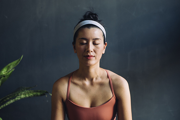 Woman meditating with eyes closed.